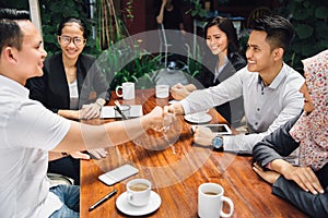 Business people shaking hands at cafe