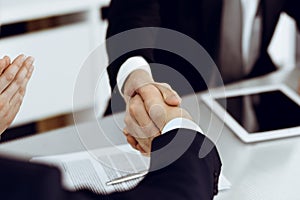 Business people shaking hands after contract signing in modern office. Teamwork and handshake concept