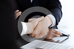 Business people shaking hands after contract signing in modern office. Teamwork, partnership and handshake concept