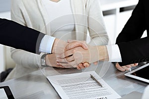 Business people shaking hands after contract signing in modern office. Teamwork, partnership and handshake concept