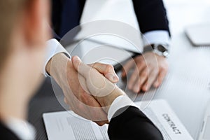 Business people shaking hands after contract signing in modern office. Teamwork, partnership and handshake concept