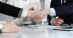 Business people shaking hands after contract signing in modern office. Teamwork, partnership and handshake concept