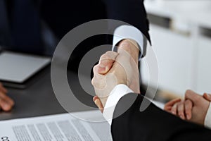 Business people shaking hands after contract signing in modern office. Teamwork, partnership and handshake concept