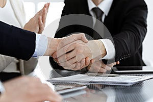 Business people shaking hands after contract signing in modern office. Teamwork, partnership and handshake concept