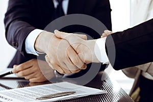 Business people shaking hands after contract signing in modern office. Teamwork, partnership and handshake concept