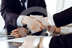 Business people shaking hands after contract signing in modern office. Teamwork, partnership and handshake concept