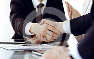 Business people shaking hands after contract signing in modern office. Teamwork, partnership and handshake concept