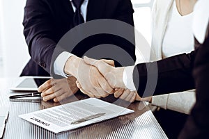 Business people shaking hands after contract signing in modern office. Teamwork, partnership and handshake concept