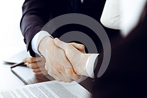 Business people shaking hands after contract signing in modern office. Teamwork, partnership and handshake concept