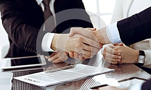 Business people shaking hands after contract signing in modern office. Teamwork, partnership and handshake concept