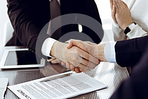 Business people shaking hands after contract signing in modern office. Teamwork, partnership and handshake concept