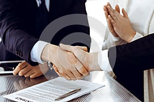 Business people shaking hands after contract signing in modern office. Teamwork, partnership and handshake concept