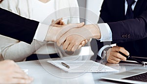 Business people shaking hands after contract signing in modern office. Teamwork, partnership and handshake concept