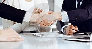 Business people shaking hands after contract signing in modern office. Teamwork, partnership and handshake concept