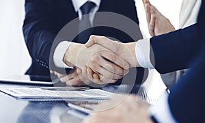 Business people shaking hands after contract signing in modern office. Teamwork, partnership and handshake concept