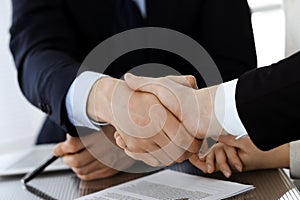 Business people shaking hands after contract signing in modern office. Teamwork, partnership and handshake concept