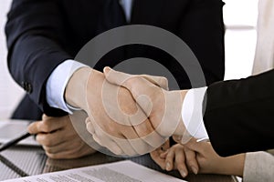 Business people shaking hands after contract signing in modern office. Teamwork, partnership and handshake concept