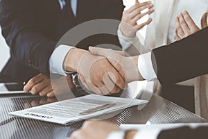 Business people shaking hands after contract signing in modern office. Teamwork, partnership and handshake concept