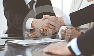 Business people shaking hands after contract signing in modern office. Teamwork, partnership and handshake concept