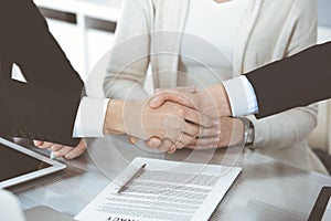 Business people shaking hands after contract signing in modern office. Teamwork, partnership and handshake concept