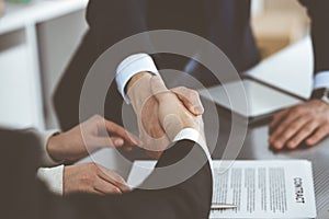 Business people shaking hands after contract signing in modern office. Teamwork, partnership and handshake concept