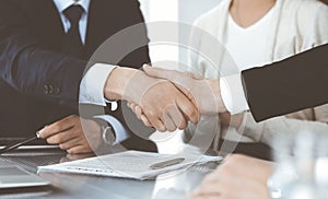 Business people shaking hands after contract signing in modern office. Teamwork, partnership and handshake concept