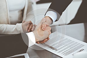 Business people shaking hands after contract signing in modern office. Teamwork, partnership and handshake concept