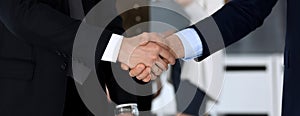 Business people shaking hands after contract signing in modern office. Unknown businessman, male entrepreneur with