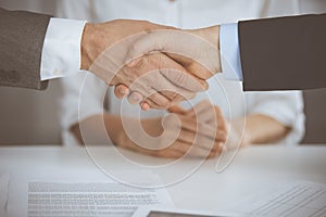 Business people shaking hands finishing contract signing, close-up. Business communication concept. Handshake and