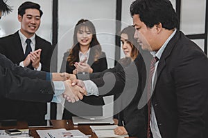 Business people shaking hands after finishing up meeting. co worker colleagues handshaking after conference.