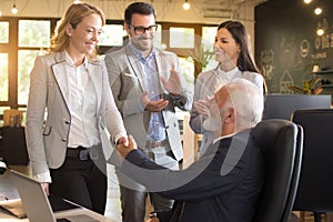 Business people shaking hands, finishing up a meeting in modern office workplace
