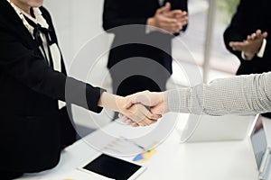 Business people shaking hands, finishing up a meeting to seal a