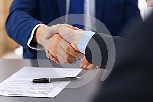 Business people shaking hands, finishing up a papers signing. Meeting, contract and lawyer consulting concept