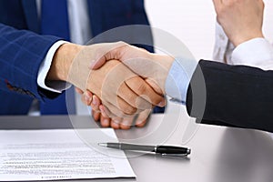 Business people shaking hands, finishing up a papers signing. Meeting, contract and lawyer consulting concept