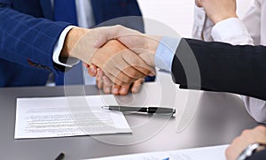 Business people shaking hands, finishing up a papers signing. Meeting, contract and lawyer consulting concept