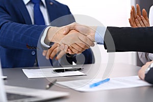 Business people shaking hands, finishing up a papers signing. Meeting, contract and lawyer consulting concept