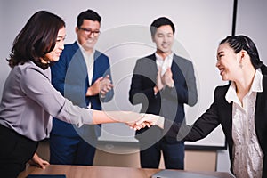 Business people shaking hands, between meeting in seminar room