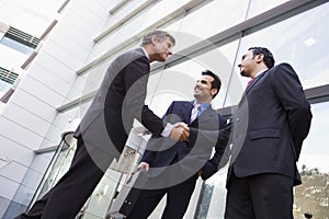 Business people shaking hands outside office