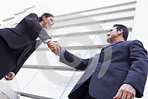 Business people shaking hands outside office