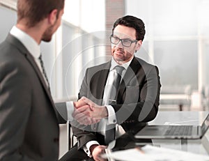 Business people shaking hands over a Desk