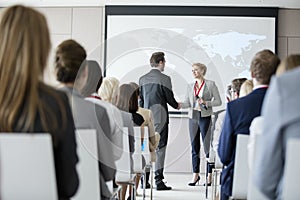 Business people shaking hands during seminar at convention center