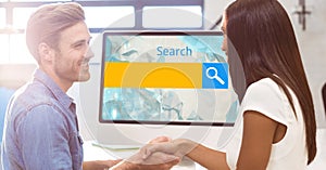 Business people shaking hands while standing by computer with search text