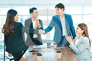 Business people shaking hands. Young modern man and woman in smart casual wear shaking hands.