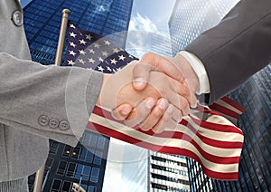 Business people shaking their hands against american flag and skyscraper