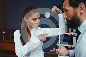 Business people showing muscles in office