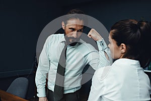 Business people showing muscles in office