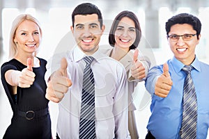 Business people showing thumbs up sign