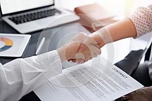 Business people signing contract papers while sitting at the glass table in office, closeup. Partners or lawyers working