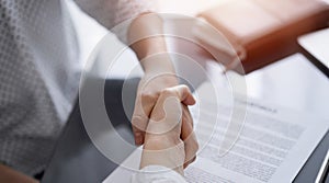 Business people signing contract papers while sitting at the glass table in office, closeup. Partners or lawyers working