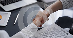 Business people signing contract papers while sitting at the glass table in office, closeup. Partners or lawyers working